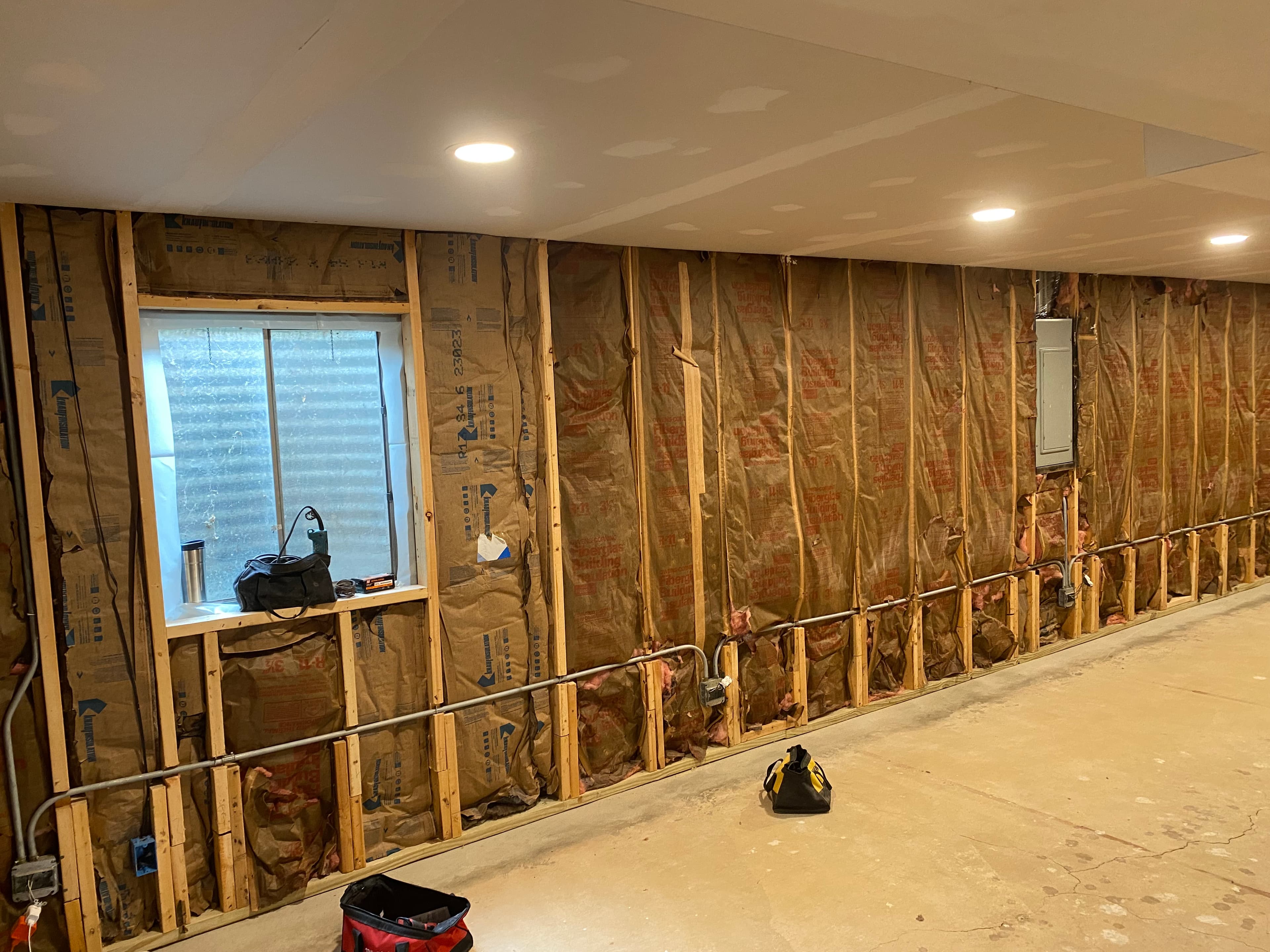 Basement before completion, with exposed wall framing and insulation.