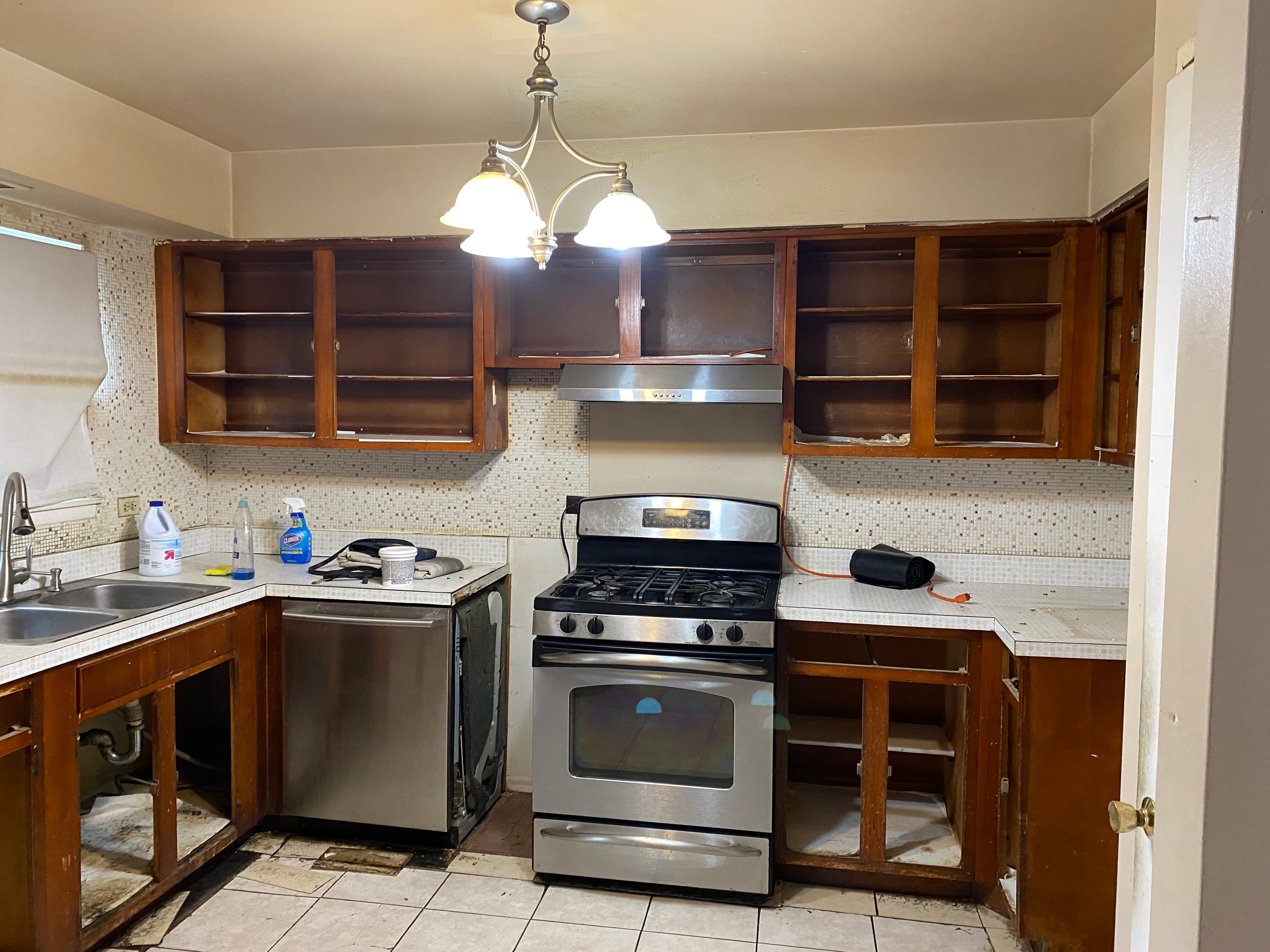 Kitchen before remodeling, with exposed cabinet interiors and the original finishes.